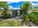 Inviting back patio area with lush landscaping and a comfortable lounge chair, perfect for relaxation at 3530 Wilkinson Woods Dr # 14, Sarasota, FL 34231