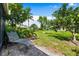 Landscaped backyard features a pond, metal chair, and lush tropical foliage at 3530 Wilkinson Woods Dr # 14, Sarasota, FL 34231