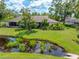 Expansive backyard with a tranquil pond, lush green lawn, and comfortable outdoor seating area at 3530 Wilkinson Woods Dr # 14, Sarasota, FL 34231