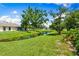 Scenic backyard view featuring a tranquil pond, lush greenery, and well-maintained lawn at 3530 Wilkinson Woods Dr # 14, Sarasota, FL 34231