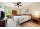 Well-lit bedroom features a ceiling fan, wood floors, a large window, and matching furniture at 3530 Wilkinson Woods Dr # 14, Sarasota, FL 34231