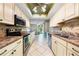 Well-lit kitchen features ample cabinet space, modern appliances, and tiled floor at 3530 Wilkinson Woods Dr # 14, Sarasota, FL 34231