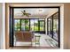 Enclosed lanai with comfortable seating, ceiling fan, tiled floors, and a view of the lush backyard at 3530 Wilkinson Woods Dr # 14, Sarasota, FL 34231