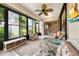 Enclosed lanai with comfortable seating, ceiling fan, tiled floors, and view of the serene landscaped yard at 3530 Wilkinson Woods Dr # 14, Sarasota, FL 34231