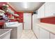 Functional laundry room equipped with a washing machine, dryer, storage cabinets, and ample countertop space at 3530 Wilkinson Woods Dr # 14, Sarasota, FL 34231