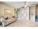 Bright living room with custom built-in shelving, a floral sofa, and tile flooring at 3530 Wilkinson Woods Dr # 14, Sarasota, FL 34231