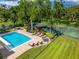 Resort style pool with plenty of lounge seating and a tennis court surrounded by mature trees and well manicured grounds at 3530 Wilkinson Woods Dr # 14, Sarasota, FL 34231