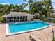 Sparkling community pool with bath house for a refreshing escape during warm summer days surrounded by lush landscaping at 3530 Wilkinson Woods Dr # 14, Sarasota, FL 34231