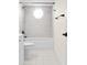 This bathroom features a tub and shower with a small window, and a tiled floor at 3551 65Th Avenue E Cir, Sarasota, FL 34243