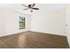 Bright bedroom featuring wood-look flooring, ceiling fan, and a window with a view of the screened lanai at 3551 65Th Avenue E Cir, Sarasota, FL 34243