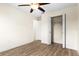 This bedroom features hardwood floors, a ceiling fan, a closet, and a door leading to another room at 3551 65Th Avenue E Cir, Sarasota, FL 34243