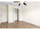 This bedroom features hardwood floors, a ceiling fan, and a closet with folding doors at 3551 65Th Avenue E Cir, Sarasota, FL 34243