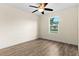 Bright bedroom featuring wood-look flooring, a ceiling fan, and a window offering natural light at 3551 65Th Avenue E Cir, Sarasota, FL 34243