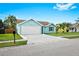 Charming aqua home showing a two-car garage, well-kept lawn, and simple landscaping at 3551 65Th Avenue E Cir, Sarasota, FL 34243