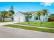 Charming, colorful home with a two-car garage, a well-manicured lawn, and palm trees at 3551 65Th Avenue E Cir, Sarasota, FL 34243