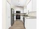 Kitchen features modern appliances, white cabinets, granite countertops, and wood-look flooring at 3551 65Th Avenue E Cir, Sarasota, FL 34243
