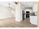 Bright living area with open floorplan, wood-look floors, and modern appliances in the kitchen at 3551 65Th Avenue E Cir, Sarasota, FL 34243