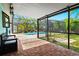 An outdoor patio with brick pavers leads to a screened-in pool area surrounded by tropical landscaping at 3551 65Th Avenue E Cir, Sarasota, FL 34243