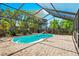 The screened-in pool with patio is surrounded by lush greenery and features a basketball hoop at 3551 65Th Avenue E Cir, Sarasota, FL 34243