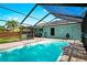 A refreshing screened-in pool with patio and view of the backyard and landscaping at 3551 65Th Avenue E Cir, Sarasota, FL 34243