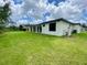 Expansive backyard view shows the home's rear and open lawn space at 3616 Bellefonte Ave, North Port, FL 34286