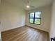 Bedroom featuring wood-look flooring, a modern ceiling fan and a large window with dark trim at 3616 Bellefonte Ave, North Port, FL 34286