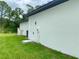 Exterior view of a modern home with a white facade, set against a lush green lawn at 3616 Bellefonte Ave, North Port, FL 34286