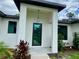 Inviting home entrance featuring a modern glass front door, manicured landscaping, and stylish exterior lighting at 3616 Bellefonte Ave, North Port, FL 34286