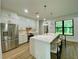 Modern kitchen with white cabinetry, quartz countertops, stainless steel appliances, and breakfast bar seating at 3616 Bellefonte Ave, North Port, FL 34286