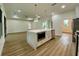 Bright open space features wood-look flooring, a kitchen island, and pendant lighting at 3616 Bellefonte Ave, North Port, FL 34286