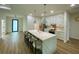 Stylish kitchen with white cabinets, stainless steel appliances, quartz countertops, and an island with bar stools at 3616 Bellefonte Ave, North Port, FL 34286