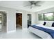 Bright bedroom featuring large windows, white floors, walk-in closet, and modern ceiling fan at 3636 Mineola, Sarasota, FL 34239