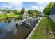 A private dock with a boat lift sits on a calm canal, surrounded by lush landscaping and nearby homes at 3636 Mineola, Sarasota, FL 34239