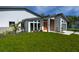 Modern home exterior with an orange front door, green lawn and contemporary design at 3636 Mineola, Sarasota, FL 34239