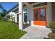 Inviting front entrance featuring a vibrant orange double door and well-maintained landscaping at 3636 Mineola, Sarasota, FL 34239