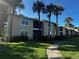 Inviting two-story condo building featuring mature palm trees and a well-manicured lawn at 4002 Crockers Lake Blvd # 11, Sarasota, FL 34238