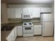 Functional kitchen featuring white appliances, neutral countertops, and ample cabinet space at 4002 Crockers Lake Blvd # 11, Sarasota, FL 34238