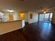 Open-concept living room with hardwood floors, fan and sliding glass doors to screened porch at 4002 Crockers Lake Blvd # 11, Sarasota, FL 34238