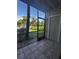 Enclosed patio featuring tile flooring and views of a well-maintained lawn with mature trees at 4002 Crockers Lake Blvd # 11, Sarasota, FL 34238