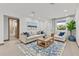 Inviting living room with neutral furniture, blue accents, a large window, and an open doorway at 405 Sunset N Rd, Rotonda West, FL 33947