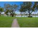 Serene backyard with walkway, pond, and mature trees in a neighborhood setting at 4414 Mount Vernon Dr # 1, Bradenton, FL 34210