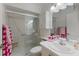 All-white bathroom features a glass-enclosed shower and a large vanity with bright pink towels at 4414 Mount Vernon Dr # 1, Bradenton, FL 34210