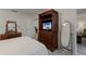Bright bedroom features a wooden dresser, a large mirror, and a flat screen television at 4414 Mount Vernon Dr # 1, Bradenton, FL 34210