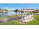 Scenic view of a covered swing overlooking a serene lake with a fountain feature, perfect for relaxation at 4414 Mount Vernon Dr # 1, Bradenton, FL 34210