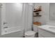 Bright bathroom with a shower-tub combo, floating shelves, and a neutral color palette at 4728 Old Blush St, Bradenton, FL 34211