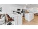 Bright white kitchen featuring stainless steel appliances, a center island, breakfast bar, and light wood floors at 4728 Old Blush St, Bradenton, FL 34211