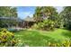 Lush backyard featuring a screened-in pool area and tropical landscaping at 4761 Pine Harrier Dr, Sarasota, FL 34231