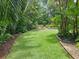 Lush backyard lawn with manicured landscaping and rock borders at 4761 Pine Harrier Dr, Sarasota, FL 34231