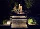 Backyard garden path and rock sculptures at night with landscape lighting at 4761 Pine Harrier Dr, Sarasota, FL 34231