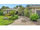 Charming home features a lush, landscaped front yard and a brick driveway at 4761 Pine Harrier Dr, Sarasota, FL 34231